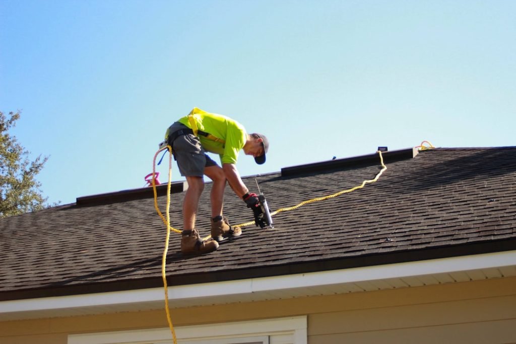 a-man-working-on-a-roof-with-a-power-drill-scaj0t40nfi